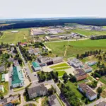 Аэросъёмка центра агрогородка Парохонск с административными и жилыми зданиями на фоне полей и леса