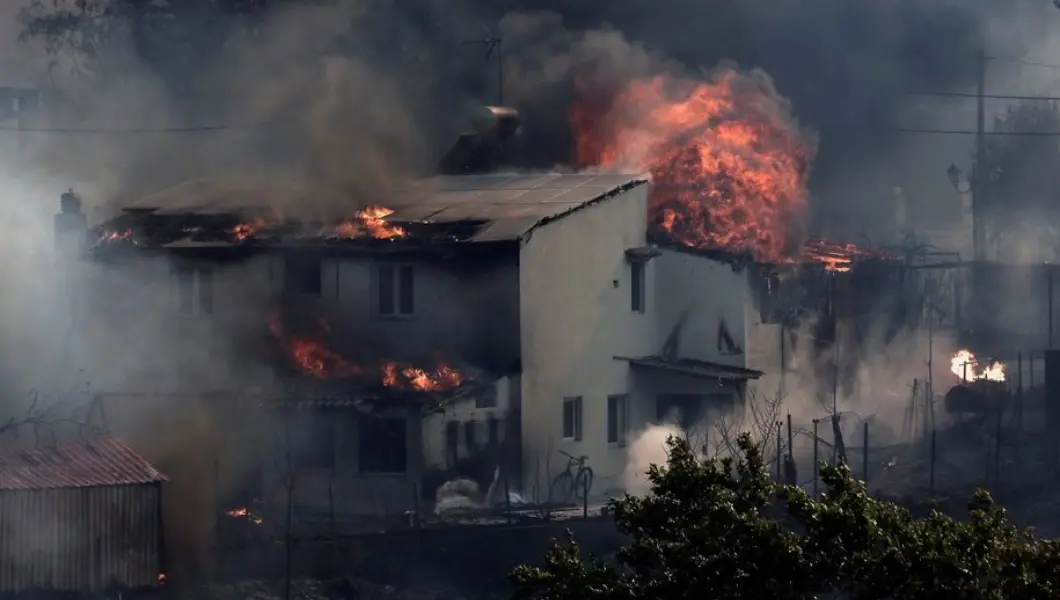 Пылающая Греция: 11 регионов под угрозой Горящий жилой дом, охваченный огнём и дымом во время лесных пожаров в пригороде Афин