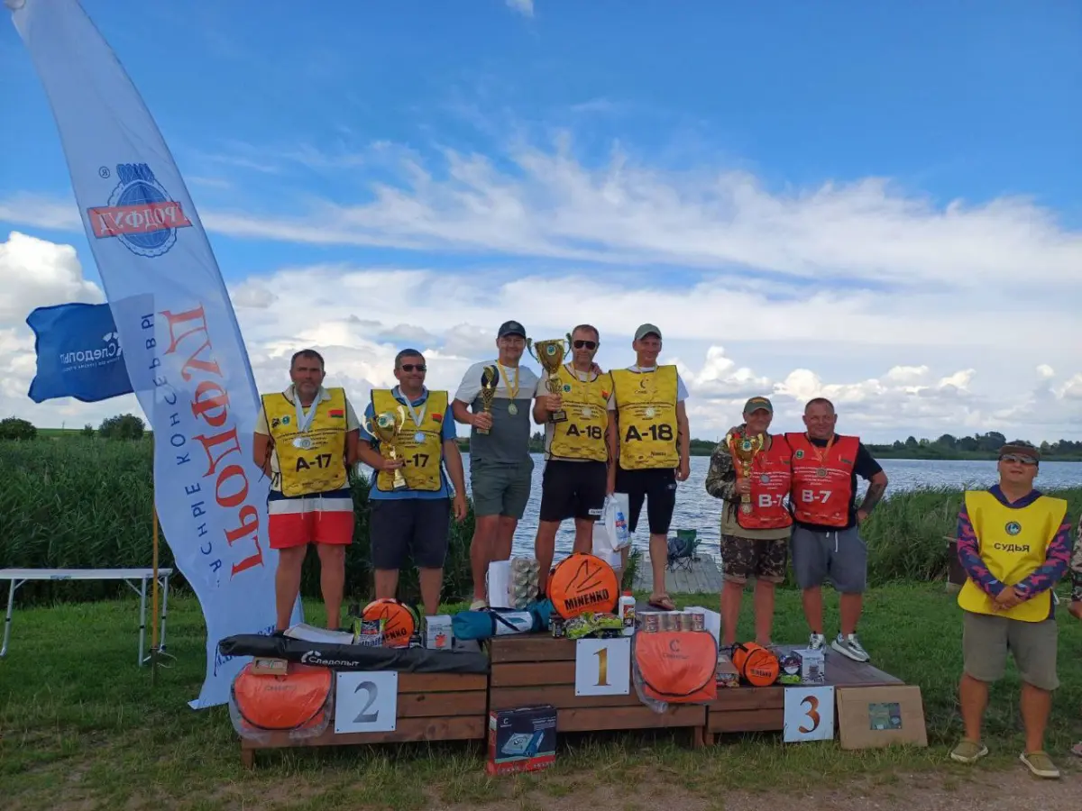 Победители соревнований по ловле карпа на подиуме с трофеями