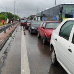 Легковые автомобили и туристические автобусы стоят в очереди на пропускном пункте в дождливую погоду