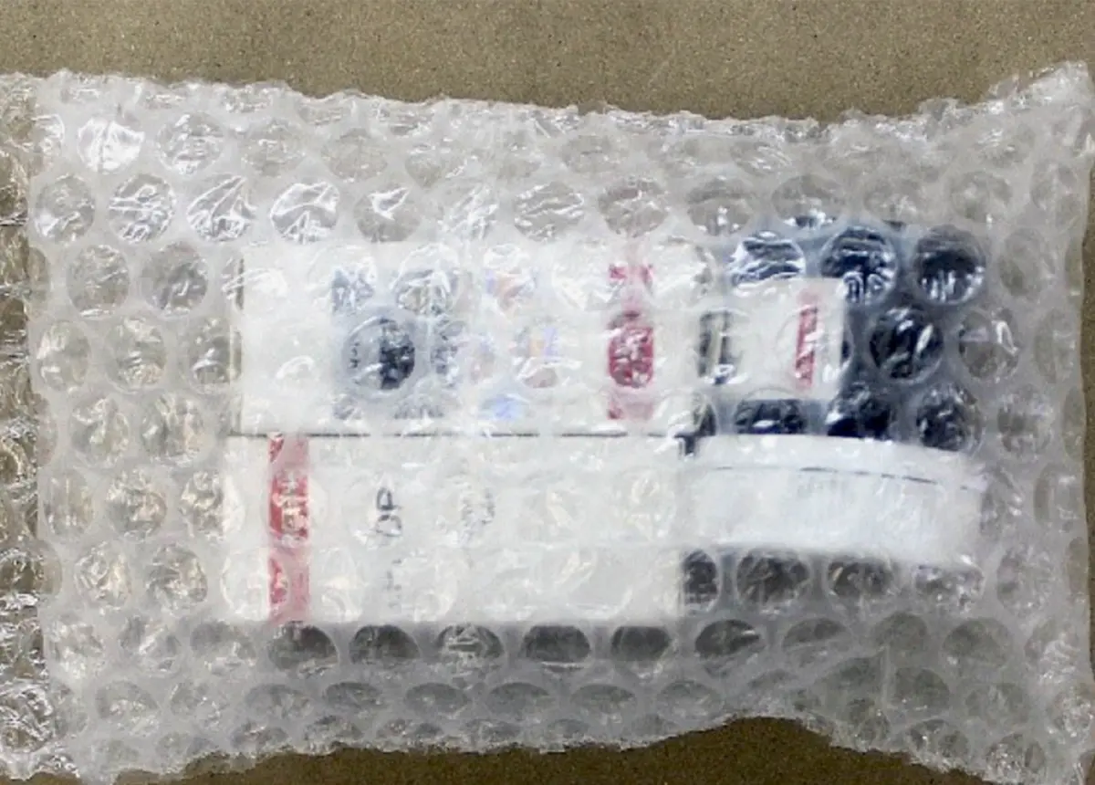 Почтовая посылка, упакованная в пузырчатую плёнку, внутри видны баночки с препаратами