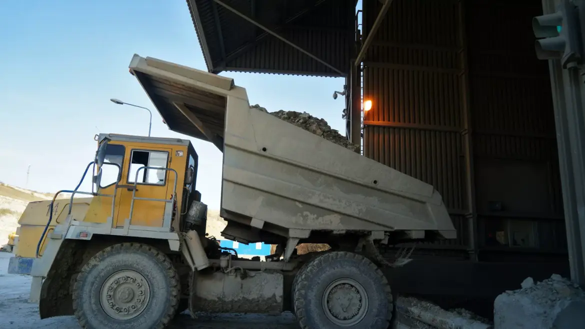 Самосвал выгружает камень на цементном заводе.