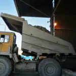Самосвал выгружает камень на цементном заводе.
