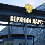 Вывеска «Верхний Ларс» на фоне горного пейзажа, пограничный переход между Россией и Грузией.