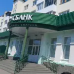 Фасад отделения Белагропромбанка в Барановичах с зелёной вывеской и входом по лестнице.