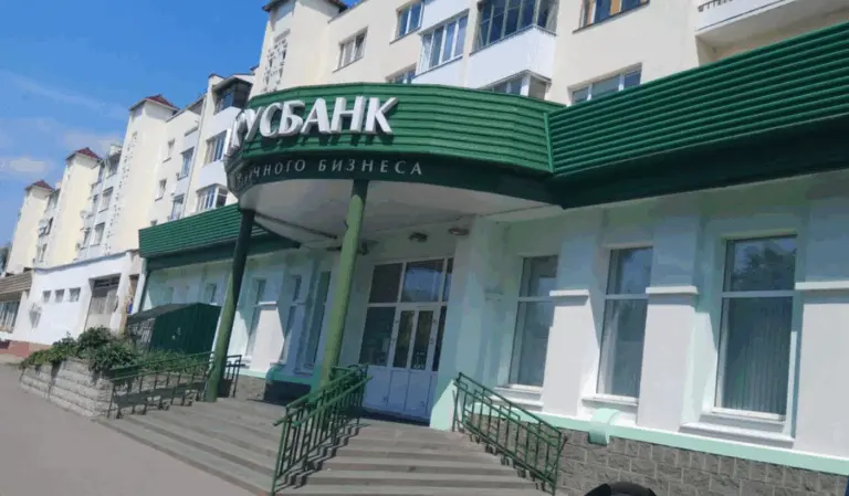 Фасад отделения Белагропромбанка в Барановичах с зелёной вывеской и входом по лестнице.