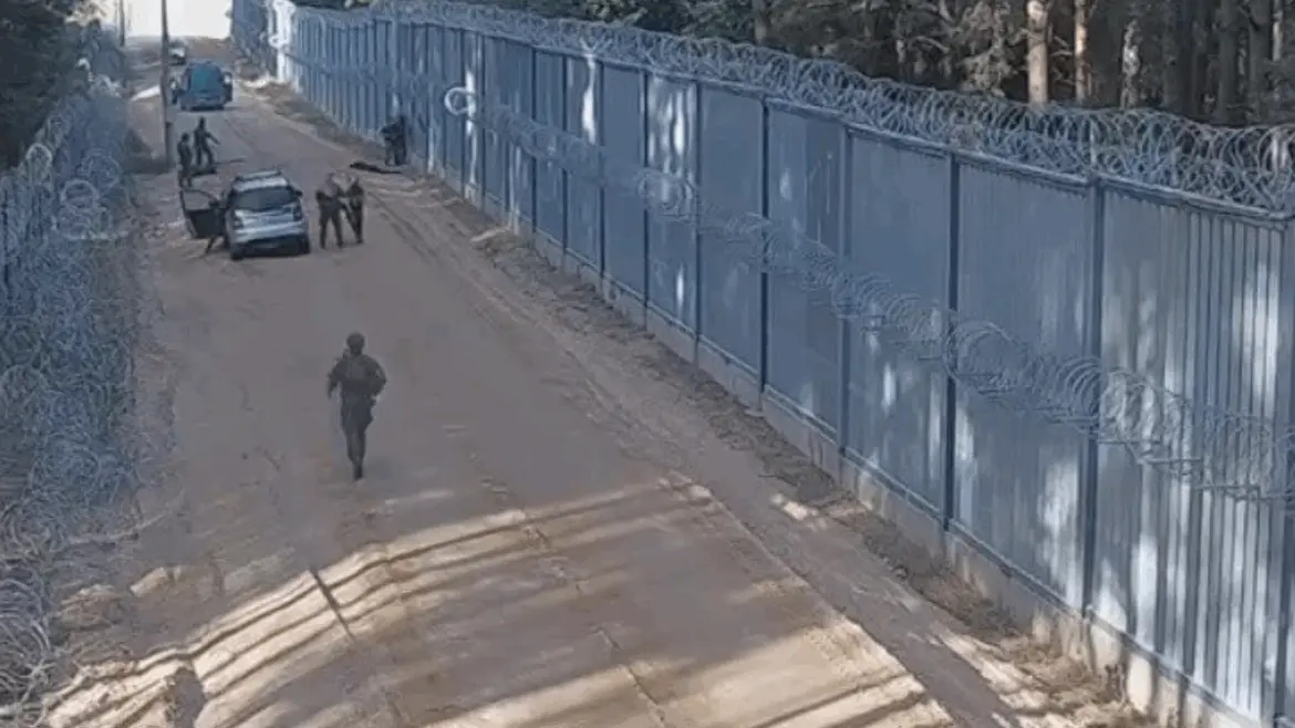 Польские пограничники на участке границы возле заграждения, автомобиль и задержанные мигранты