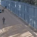 Польские пограничники на участке границы возле заграждения, автомобиль и задержанные мигранты