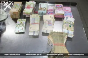 крупные стопки купюр номиналом 100, 200, 500 и 1000 гривен, разложенные на металлическом столе в таможне.
