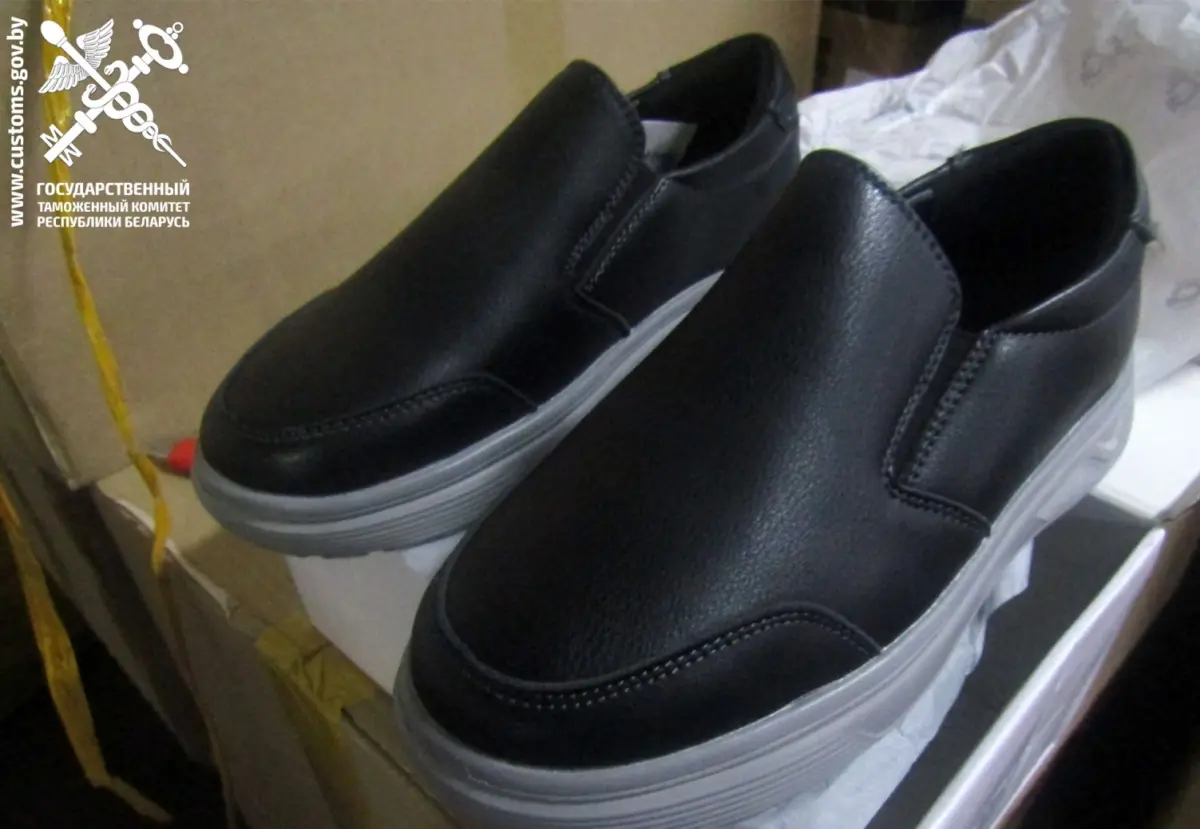 пара мужской обуви чёрного цвета на светлой подошве, выставленная для проверки таможней.