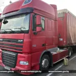 красный грузовик DAF с прицепом на стоянке таможенного терминала, использовался перевозчиком, у которого выявили подделку VIN-номера, криминал.