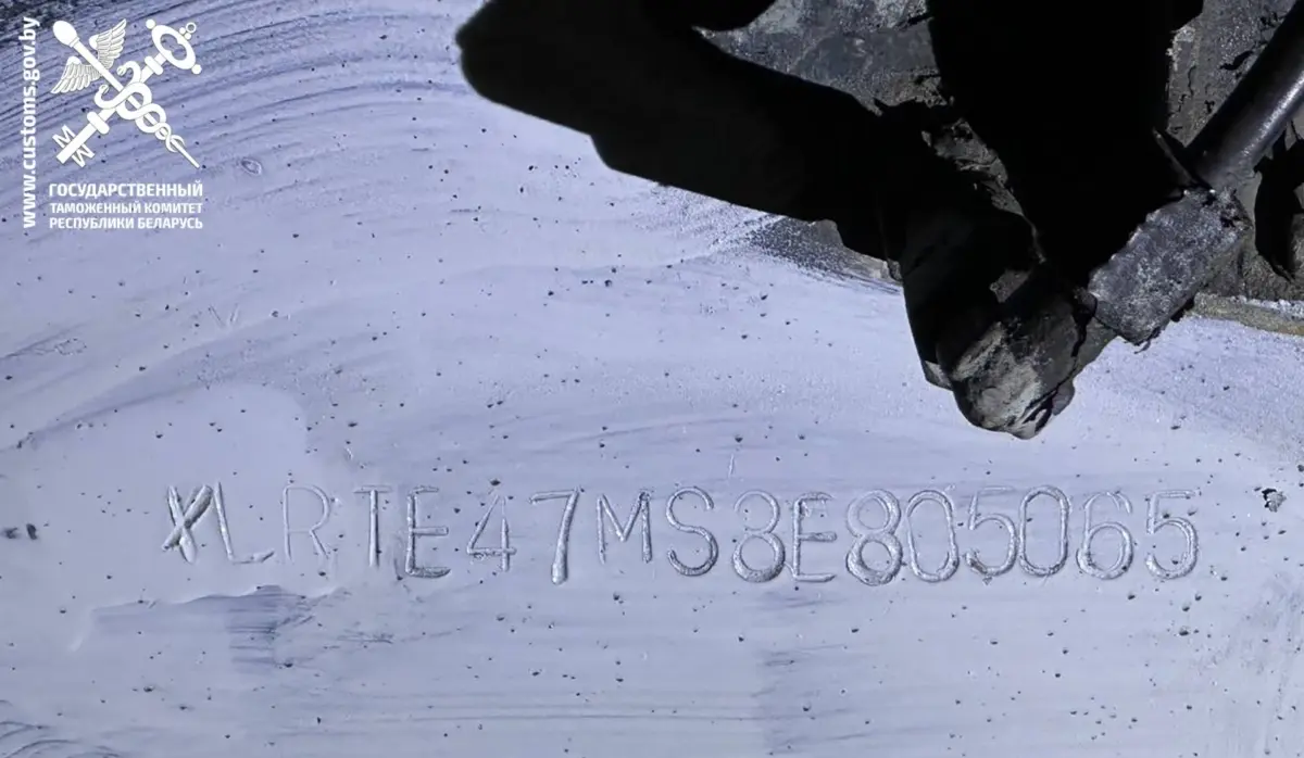 крупный план поддельного VIN-номера на кузове грузовика, видно, что металл обработан и цифры выбиты заново, криминал