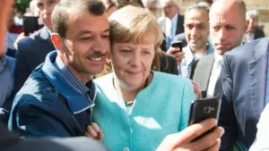 Канцлер Ангела Меркель и беженец в 2015 году