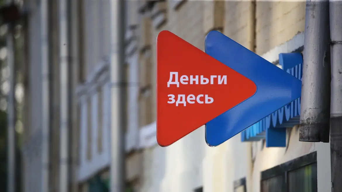 Вывеска с надписью «Деньги здесь» на фасаде здания