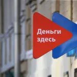 Вывеска с надписью «Деньги здесь» на фасаде здания
